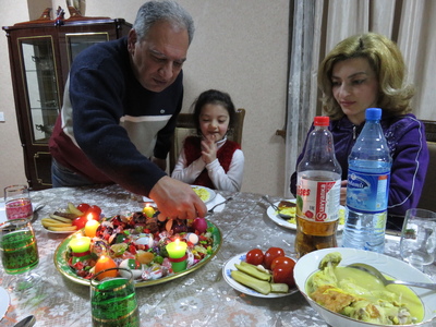 Dinner on the eve of Novruz with our host, the housekeeper, and her daughter. We were the only guests in the hostel that night. Here, our host is lighting the candles on the "khoncha", a festive tray filled with sweets, nuts, and colourful eggs.