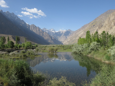 The mountains of the Bartang valley, one of the valleys branching off from the Panj river between Qalai Khumb and Khorog leading to the high Pamirs, reflected in a small pond just after the turn-off