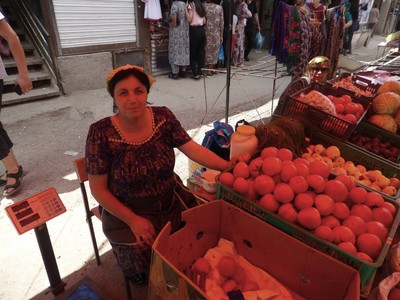 Vegetable vendor in the Khorog bazaar, wearing a cabbage leaf on her head to stay cool in the heat