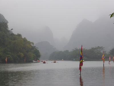 Tourist boats rowing down the river and into the mist-ical karst landscape at Trang An, Ninh Binh